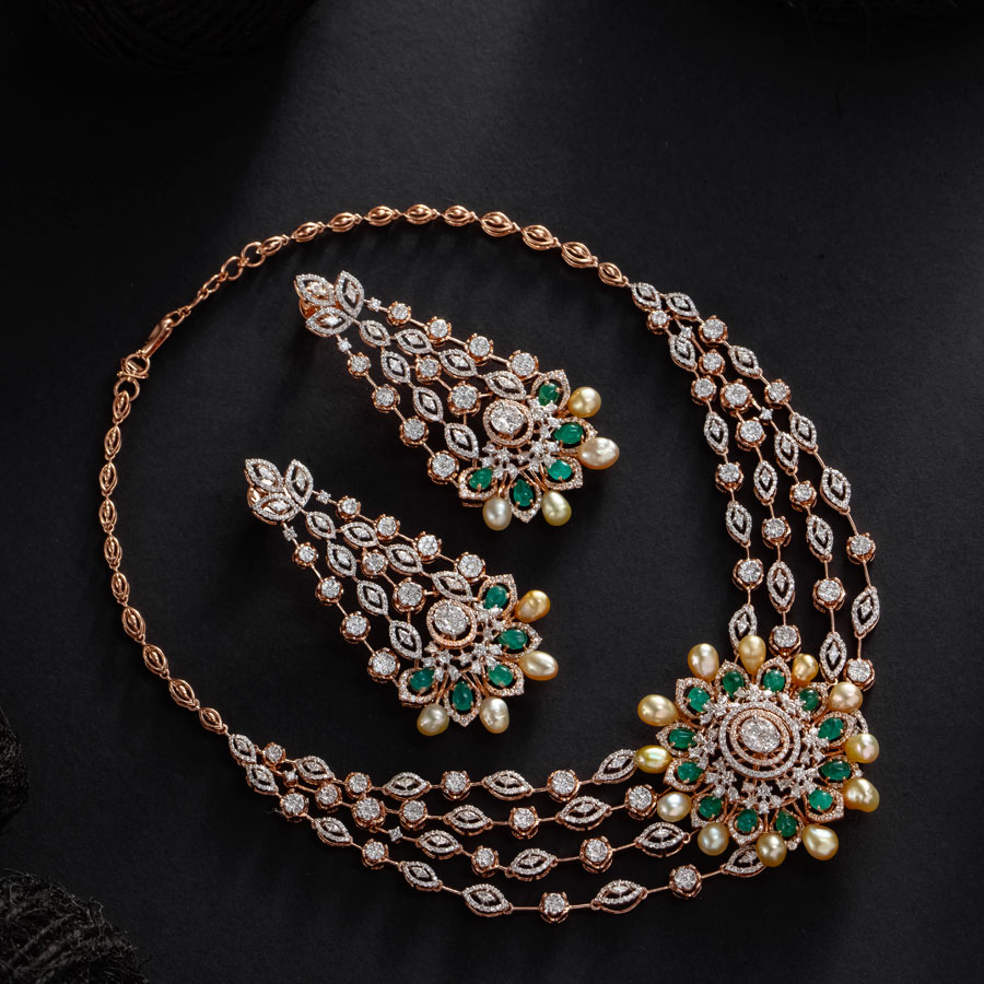 Floral emerald and diamond earrings on black background