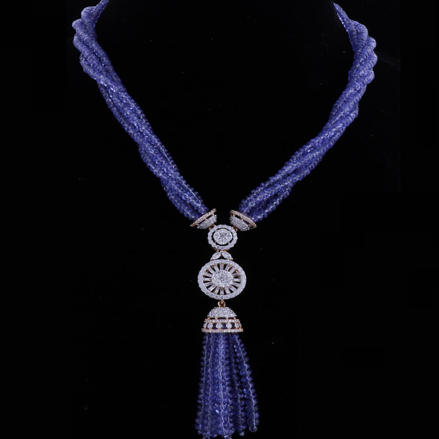 Multiple string beaded necklace with a diamond chakra pendant suspended on a black background.